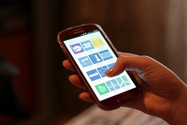 Una mano tiene uno smartphone Android con le app sullo schermo