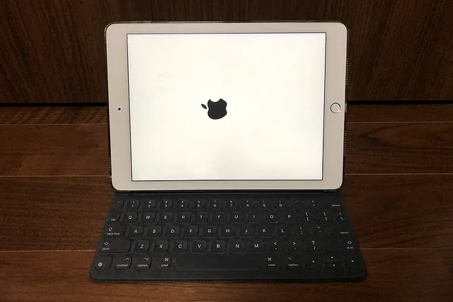 Un iPad con la tastiera appoggiato su un tavolo di legno