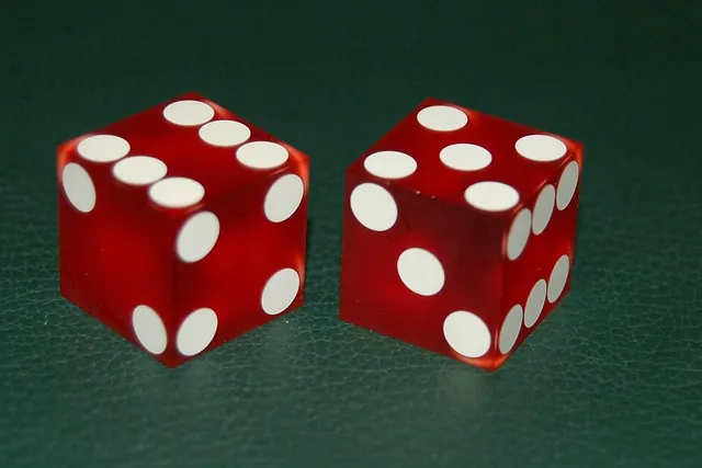 Due dadi rossi sul panno verde di un tavolo da craps