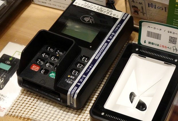 Terminale POS per carte accanto a un lettore di codici, su un bancone